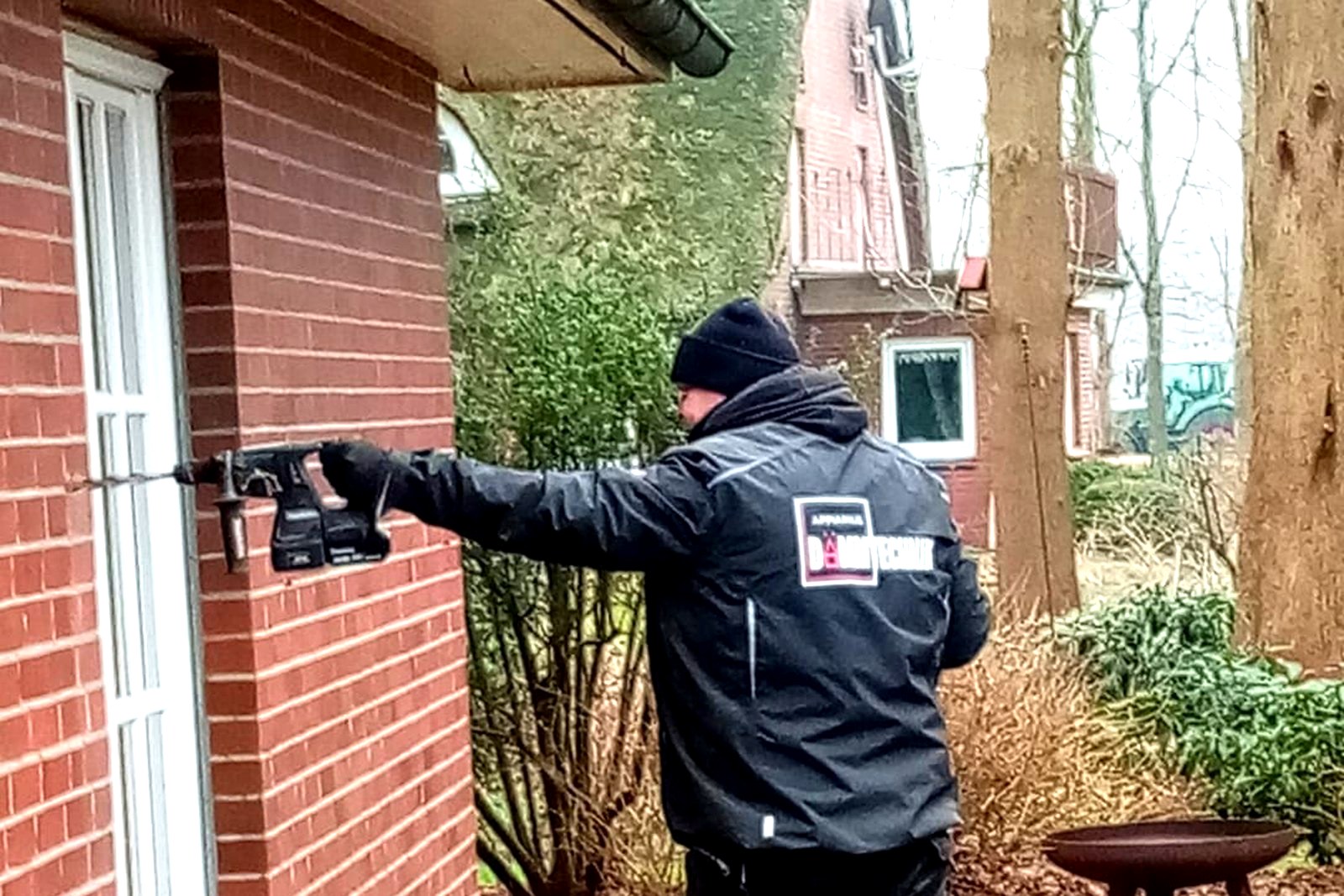 Techniker bringt Einblasdämmung in eine Klinkerfassade ein