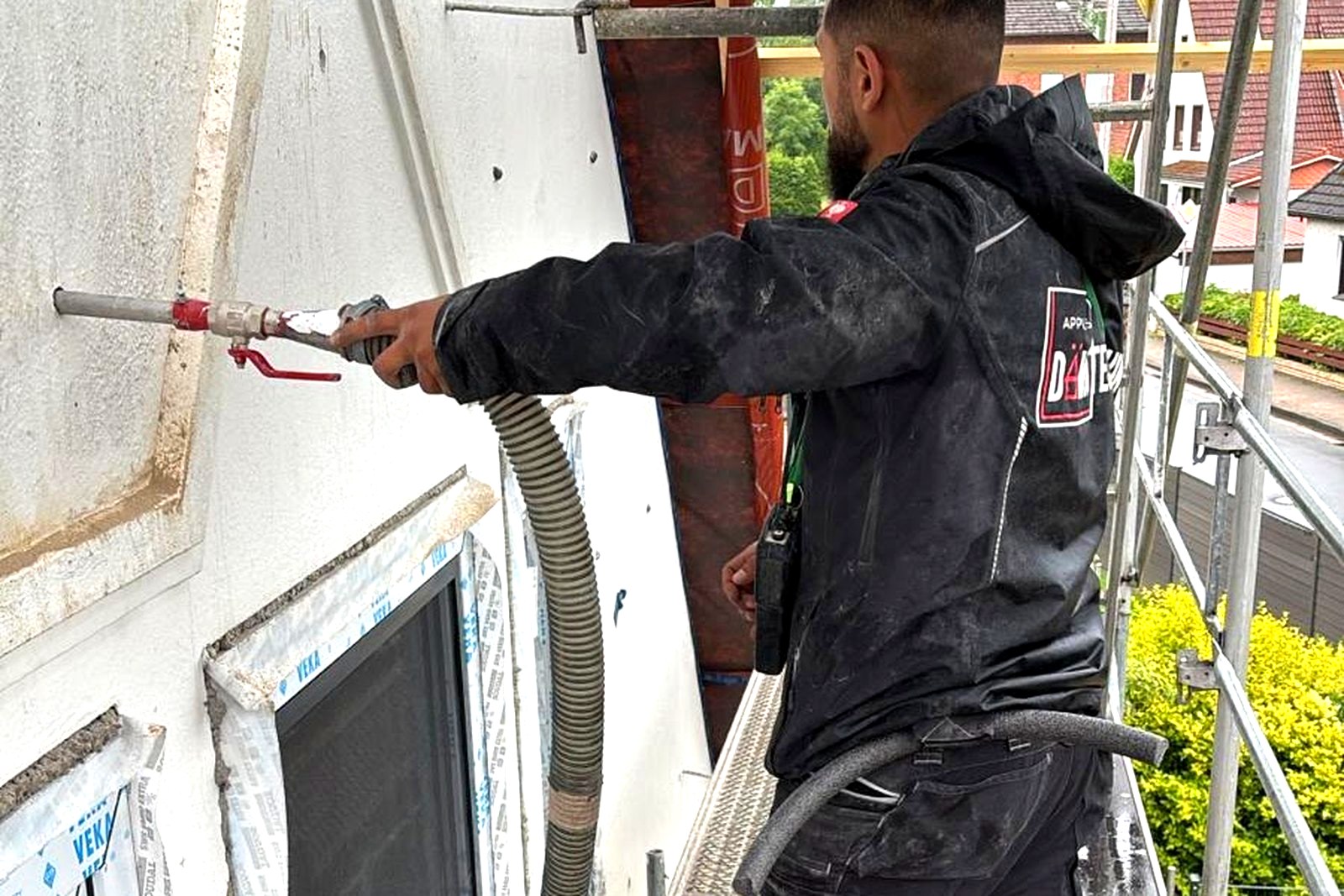 Techniker prüft eine Klinkerfassade mit einem Messgerät