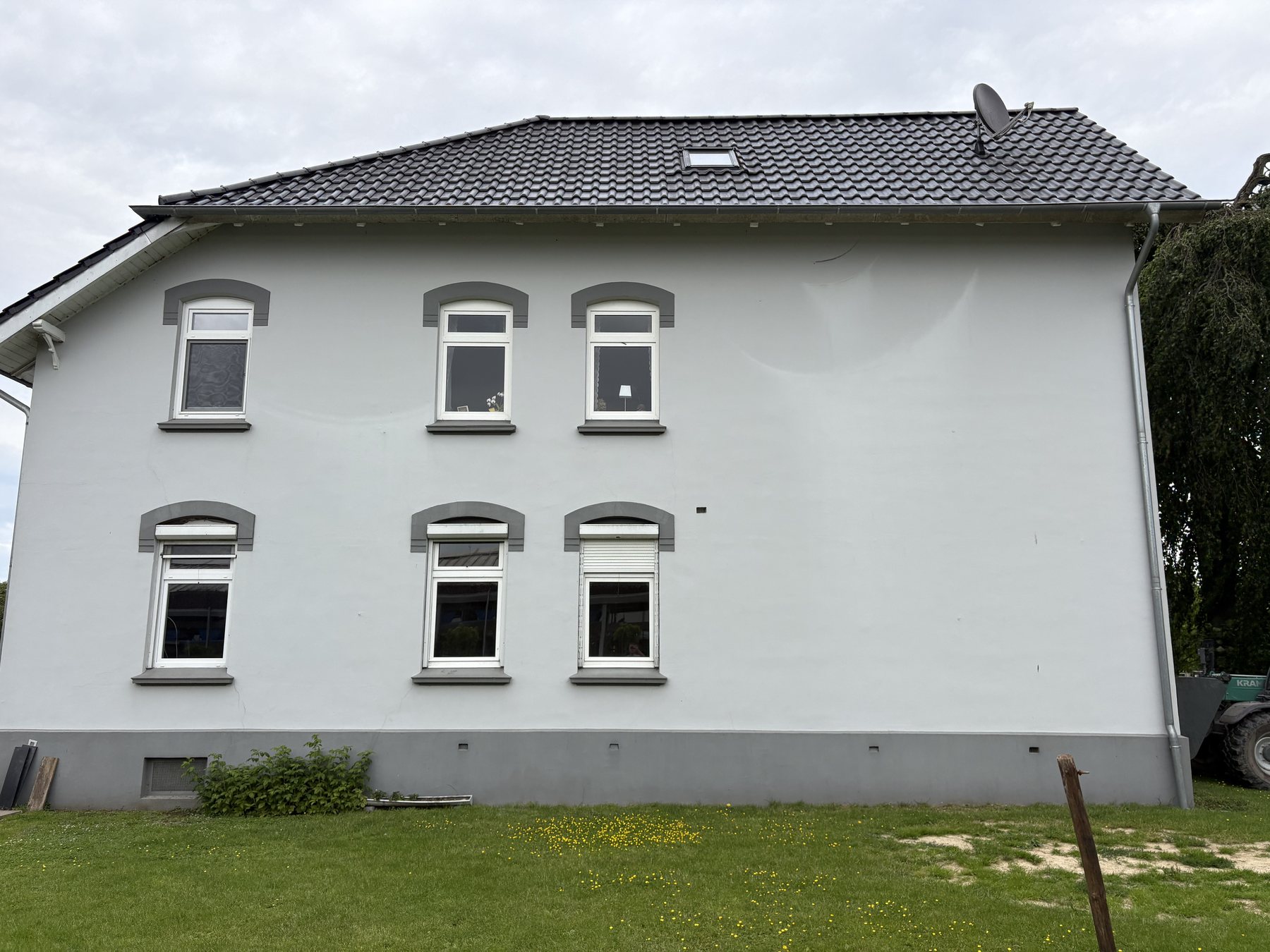Breite Giebelfassade eines verputzten Altbauwohnhauses