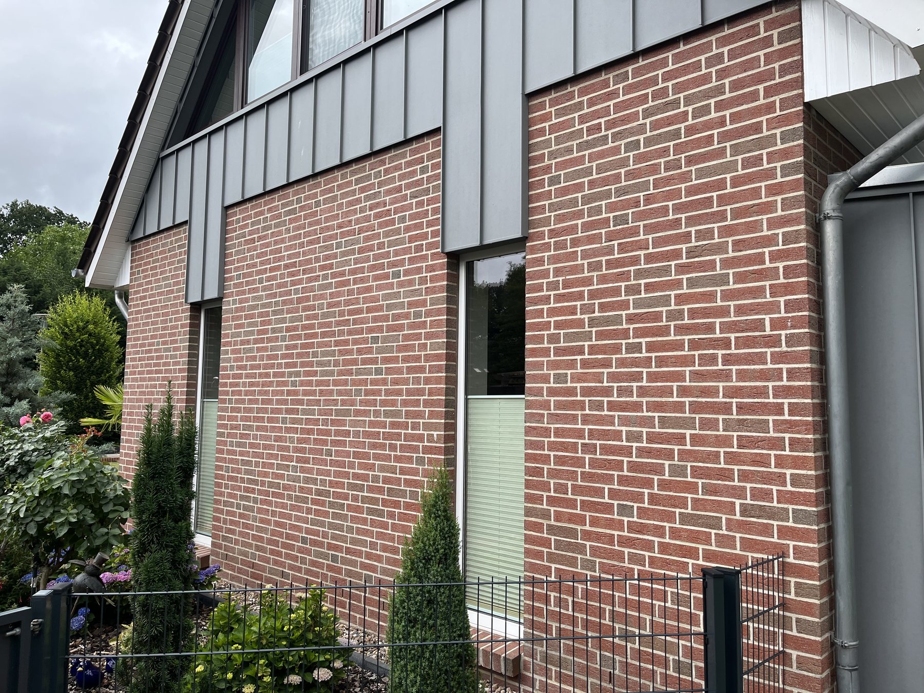 Klinkerfassade unter einer grauen Metallverkleidung